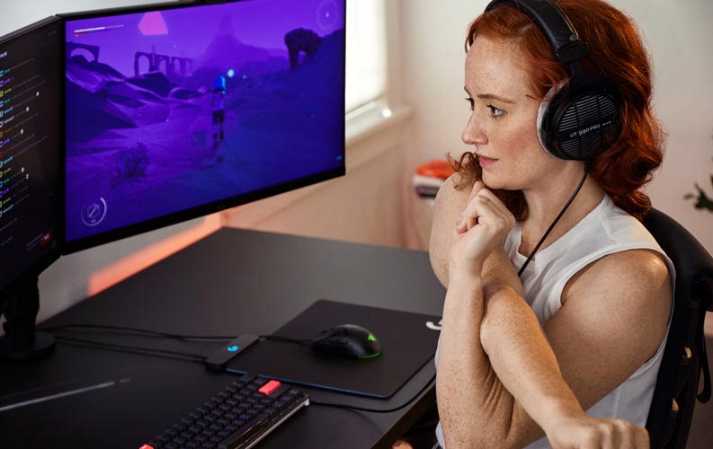 Esports-lääkäri Lindsey Migliore pelikokoonpanon edessä, jossa on kaksi monitoria Ollin-monitorivarsilla.