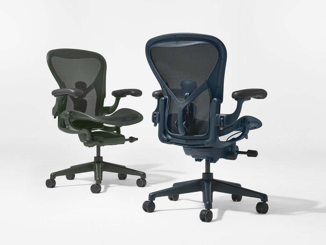 Kaksi Herman Miller Aeron -työtuolia, värit Jasper-vihreä ja Nightfall-sininen, kuvattuna valkoisessa studiossa.