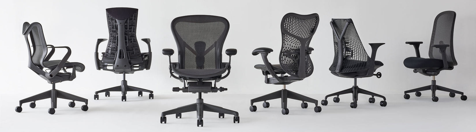 Herman Millerin kotitoimistotuolit eri kulmissa, kaikki grafiittivärisiä, mallit Cosm low back, Aeron, Mirra 2 ja Lino
