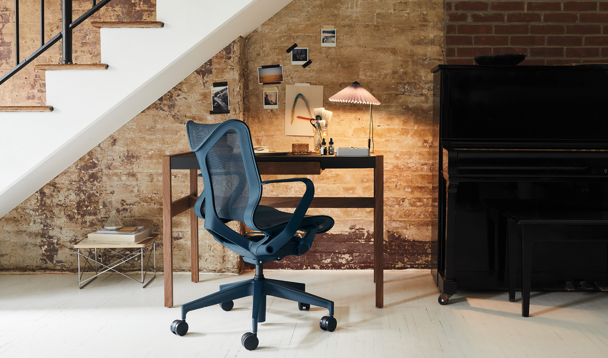 Sininen Herman Miller Cosm -työtuoli on sijoitettu työpöydän eteen ja portaikon alle kotiympäristössä.